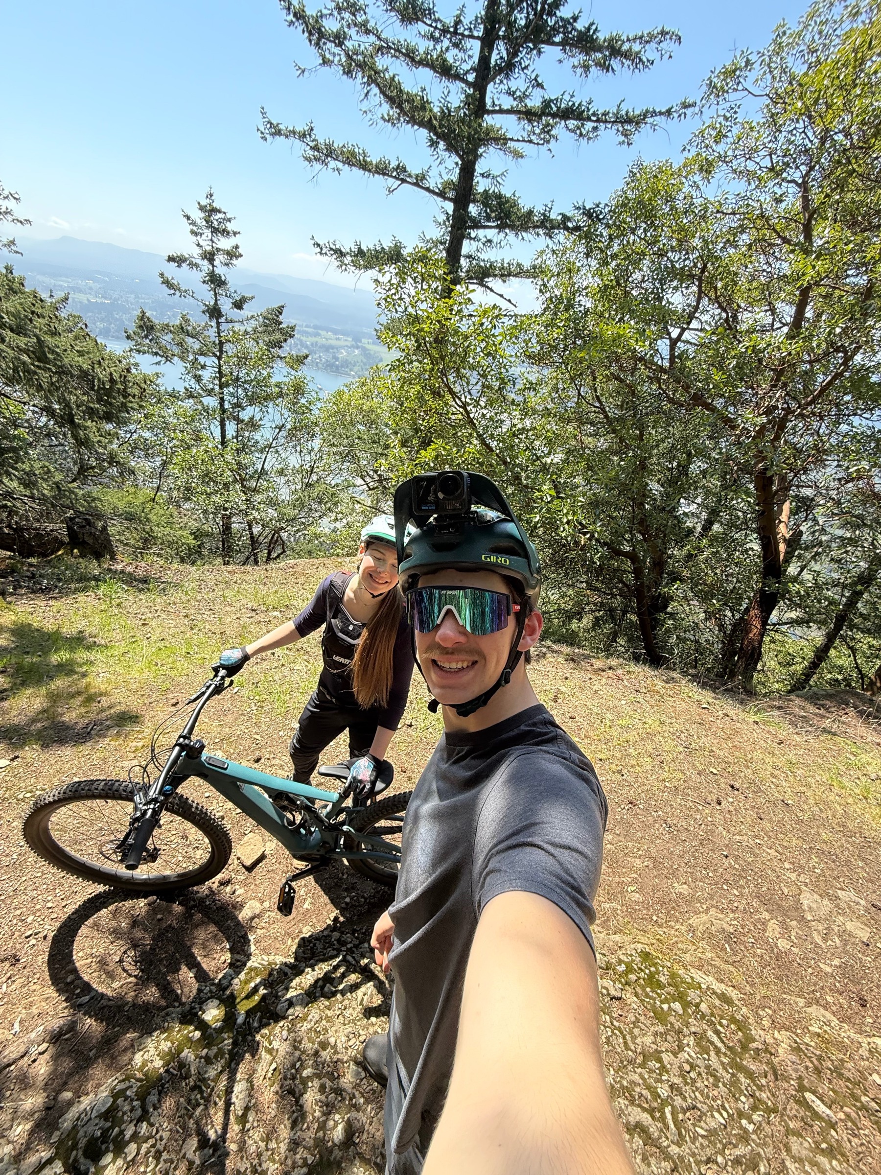 Everett Procter mountain biking on Vancouver Island trails with scenic mountain and ocean views